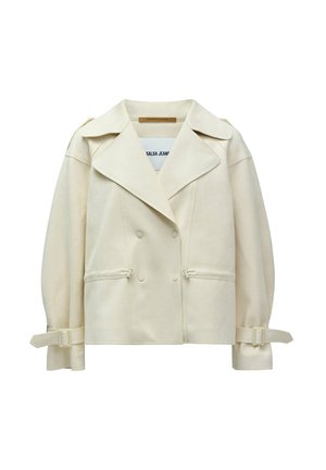 Chaqueta cremosa de doble botonadura con grandes solapas, bolsillos laterales y detalles de lazo ajustables en las mangas; confeccionada con una tela suave.