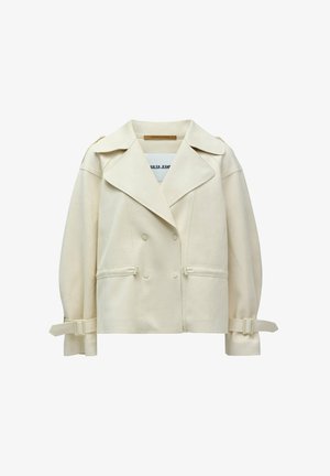 Chaqueta cremosa de doble botonadura con grandes solapas, bolsillos laterales y detalles de lazo ajustables en las mangas; confeccionada con una tela suave.