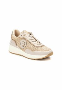 Zapatilla deportiva beige con parte superior de tejido, acentos de cuero suave, detalle de logo redondo y una suela blanca acolchada. El material texturizado añade interés.
