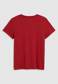T-shirt rouge à manches courtes en coton, avec un col rond et une texture lisse. La vue de dos montre un design simple et sans ornement.