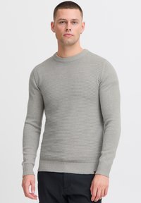 Light gray sweater with a textured ribbed design, crew neck, long sleeves, and a fitted hem. Fabric appears soft with subtle detailing.