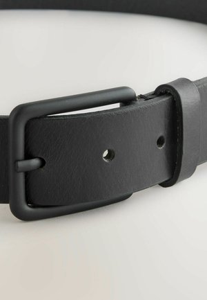 Črn usnjen pas z teksturirano površino, ki ima pravokotno kovinsko sponko v mat črni barvi in več odprtin za prilagajanje.