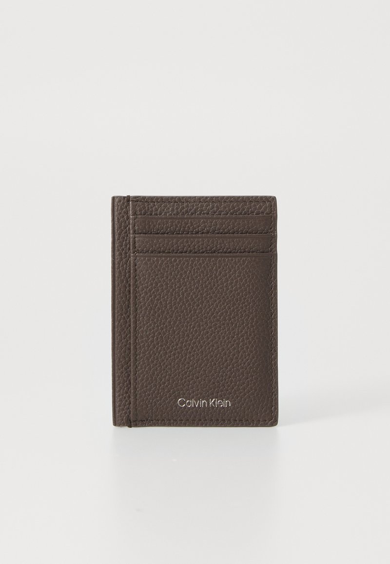 Brun lærpung med strukturert overflate, med fire kortlommer og preget logo. Kompakt størrelse for enkel bæring.