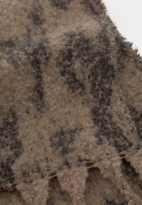 Tessuto misto lana con una superficie morbida e texture; presenta uno sfondo beige e schemi astratti grigio scuro. I bordi sono leggermente sfilacciati.