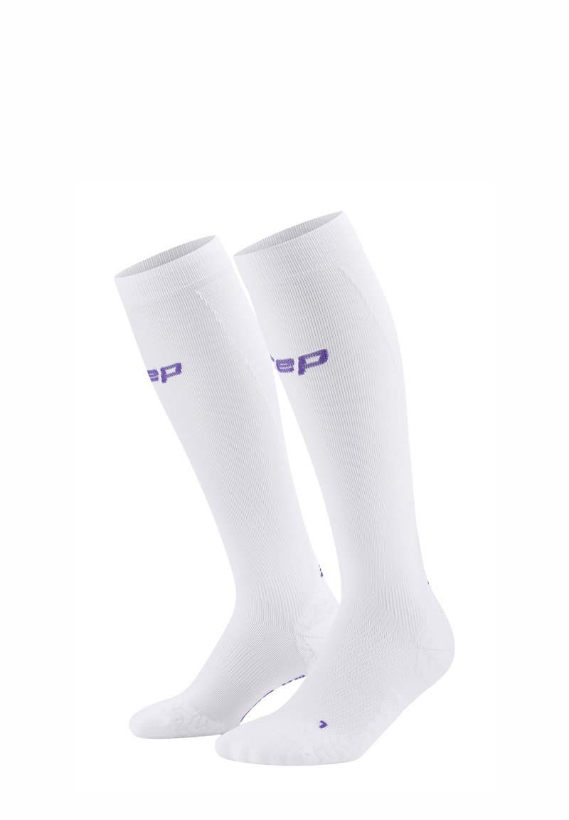 Weiße Kompressionssocken mit einem strukturierten Design, geripptem Material und einem lila Logo. Knielange Socken mit verstärkter Zehen- und Ferse.