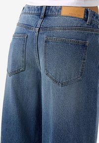 Μπλε τζιν παντελόνι με μεσαίο ύψος, που διαθέτει δύο πίσω τσέπες, ελαφριά φθορά και δερμάτινη ετικέτα με την ένδειξη "NOISY MAY."