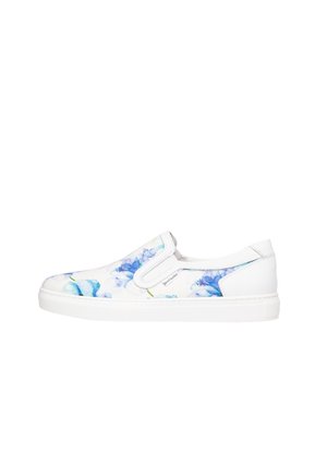 Baskets blanches sans lacets avec motif floral bleu et semelle blanche, avec des panneaux latéraux élastiques pour un enfilage facile et une petite étiquette de marque en tissu.