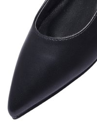 Scarpa nera con punta a punta realizzata in materiale testurizzato, caratterizzata da un design elegante con un interno liscio e senza hardware o motivi visibili.
