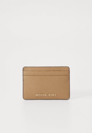Porta tessere in pelle color cuoio con finitura testurizzata, dotato di quattro scomparti per carte e logo "MICHAEL KORS" dorato sul davanti.