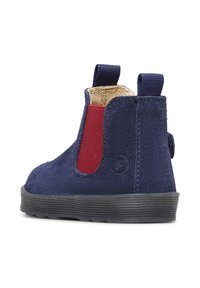 Stivaletto in suede blu scuro con pannello laterale rosso, suola in gomma testurizzata, inserti elastici e linguetta sul retro per una facile calzata.