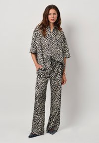 Leopard print two-piece set made of lightweight fabric; features a short-sleeved shirt and wide-leg pants with a relaxed fit.