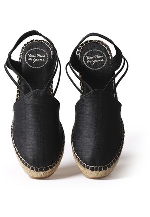 Par sorte slip-on espadriller med jutesål og tynde sorte ankelstropper, mærkelogo synligt på den inderste sål af hver sko.