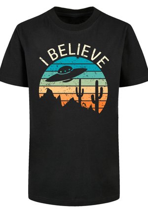 Black cotton t-shirt featuring a multi-colored circular graphic with a UFO, mountains, and cacti, with the text “I BELIEVE” in white.