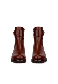 Braune Lederstiefeletten mit glatter Textur, breiten Riemen um den Knöchel, metallischen Schnallen und robusten schwarzen Gummisohlen.