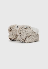 Lune dyre-inspirerede slippers i beige med bløde hvide accenter, rund form og sort bund. Designet til at ligne ansigtet på et lille dyr.