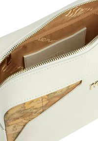 Pouch in tessuto bianco con zip dorata. L'interno presenta un motivo a mappa. Include un compartimento separato con zip.