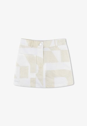 Jupe blanche avec des motifs géométriques dorés, comportant une fermeture à boutons sur le devant, deux poches avant et un petit label avec logo en bas.