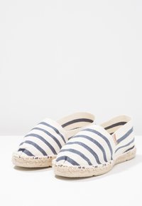 Gestreifte Leinensandaletten mit beiger Basis und navyblauen Streifen, ausgestattet mit einer gewebten Jutesohle und offenem Zehendesign.