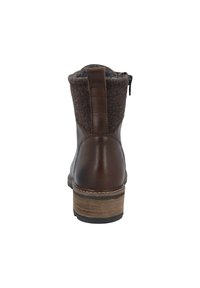 Braune Leder-Stiefelette mit einem dunkelgrauen Filzkragen, Reißverschluss und einem gestapelten Holzabsatz. Die strukturierte Oberflächendetail betont das Design.