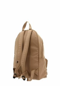 Sac à dos beige avec bretelles rembourrées, poignée supérieure et deux compartiments zippés. Fabriqué en tissu durable, présentant une texture lisse.