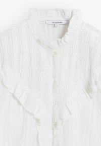 Blusa blanca con volantes, cuello y parte delantera abotonada. La tela texturizada presenta suaves rayas verticales. La etiqueta indica "SCALPERS", talla S.