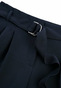 Pantaloni a vita alta blu navy realizzati in tessuto morbido, dotati di una cintura con fibbia in argento e dettagli plissettati lungo la parte anteriore.