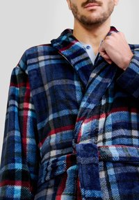 Bata de cuadros en azul marino, rojo y azul claro; hecha de un tejido suave y texturizado, con cuello de chal y cinturón de lazo.