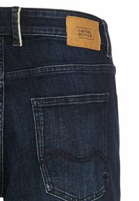 Donkerblauwe denim jeans met een gestructureerde stof, voorzien van een camelkleurige leren patch met het label "Camel Active" en versterkte stiksels.