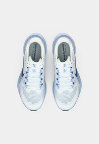 Svetele modre Nike tekaške čevlje z mrežnim zgornjim delom, ploskim vezalkami in gumijastim podplatom. Na vsaki strani je črn znak swoosh.