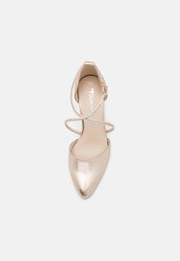 Chaussure à talon haut en rose doré métallique avec un bout pointu, une lanière à la cheville et un accent scintillant sur la lanière. Taille 37. Texture lisse.