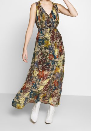 Maxikleid mit mehrfarbigem Blumenmuster, V-Ausschnitt, gerafftem Oberteil und tailliertem Schnitt mit Gürtel; kombiniert mit weißen Stiefeletten.