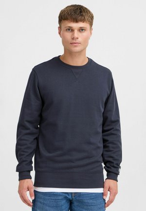 Felpa blu navy con colletto a girocollo a costine, maniche lunghe e tessuto testurizzato. Presenta un orlo aderente e un delicato logo dettagliato sul polsino.