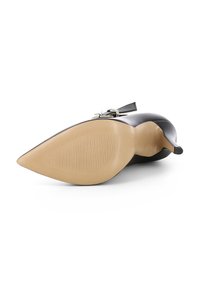 Scarpa con tacco alto in pelle nera, con punta affusolata, tacco sottile e suola in gomma color tan con scanalature orizzontali per una migliore aderenza.