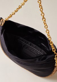 Black satin shoulder bag with a golden chain strap, curved shape, and a textured gold-accented bottom. Interior features a logo patch.