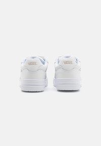 Adidași albi din piele cu o textură netedă, guler căptușit și talpă din cauciuc, având un logo Vans bej pe toc.