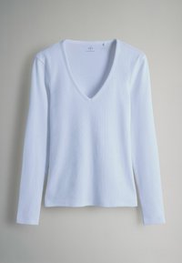Weißes Langarm-Top mit V-Ausschnitt, mit gerippter Struktur und geradem Saum. Das Material wirkt weich und leicht.