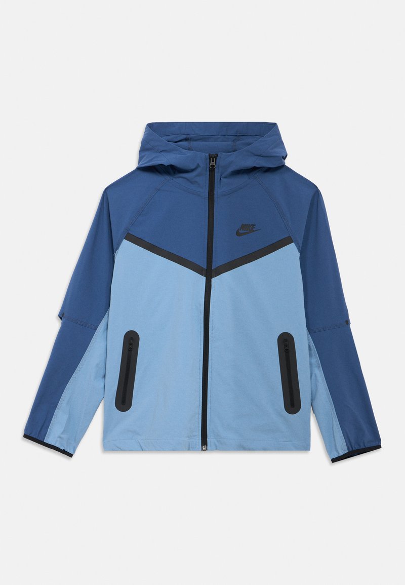 Kurtka z kapturem marki Nike w kolorach niebieskim i jasnoniebieskim, z czarnymi akcentami, dwoma kieszeniami na zamek i zamkiem błyskawicznym na przedzie.