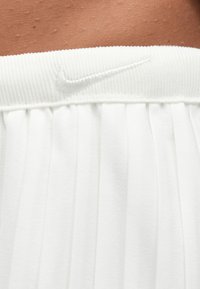 Λευκή πλισέ φούστα με ριμπ ελαστική μέση. Διαθέτει μικρό, κεντημένο λογότυπο στη μέση. Μαλακό, υφή υφάσματος.