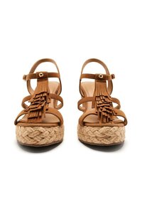 Sandali in suede marrone con dettagli in frange, pianta in juta intrecciata, design con punta aperta e cinturino alla caviglia regolabile.