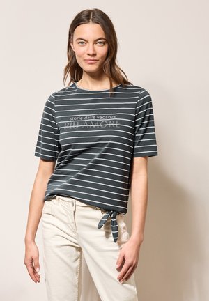 T-shirt à manches courtes vert foncé avec des rayures horizontales blanches et un détail noué à la taille, avec un texte imprimé au centre.