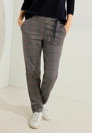 Pantalons à carreaux gris avec une taille à cordon, des poches latérales et une coupe décontractée. Portés avec des baskets blanches sur un fond neutre.