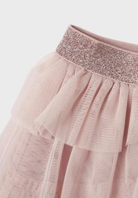 Jupe en tulle rose avec un design à couches, ornée d'une taille en rose doré pailleté. La texture est légère et aérienne, mettant en valeur de délicats volants.