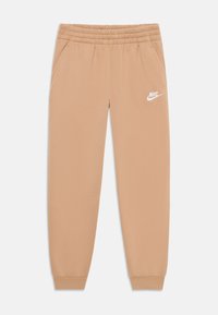 Beige Nike-housut, joissa on naru vyötäröllä, sivutaskut, joustavat hihan suut ja valkoinen logo vasemmassa jalassa. Pehmeä materiaalin rakenne.
