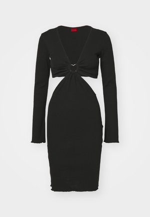 Sort langærmet kjole med dyb V-udskæring, der har en twist-detalje i taljen og et rundt hardware-accents. Glat strikket stof.