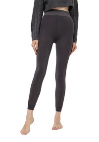 Czarne legginsy wykonane z elastycznego materiału, z wysokim stanem i zwężanymi nogawkami. Gładka faktura bez wzorów czy akcentów.
