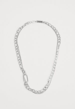 Sudraba ķēdes kaklarota ar metāla saitēm un rindu mazu baltu pērļu. Iekļauts regulējams aizdare drošai piekļaušanai.