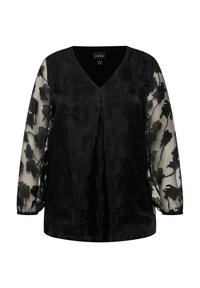 Schwarze Bluse mit V-Ausschnitt, ausgestattet mit transparenten langen Ärmeln, die mit floralen Mustern verziert sind. Der Körper besteht aus einem strukturierten, blickdichten Stoff.