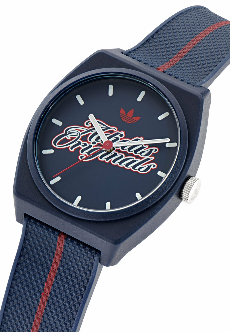 Marineblaue Adidas Originals Uhr mit weißen Stundenmarkierungen, rotem Sekundenzeiger und strukturiertem Armband mit rotem Streifen.