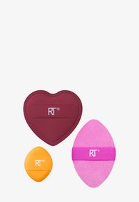 Tre spugnette per trucco: una spugna a forma di cuore color bordeaux, una spugna ovale gialla e una spugna rosa con una fascia viola, tutte con un logo.