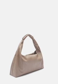 Beżowa skórzana torebka o miękkiej, teksturowanej strukturze, z zakrzywionym uchwytem i uporządkowanym, trapezoidalnym kształtem.